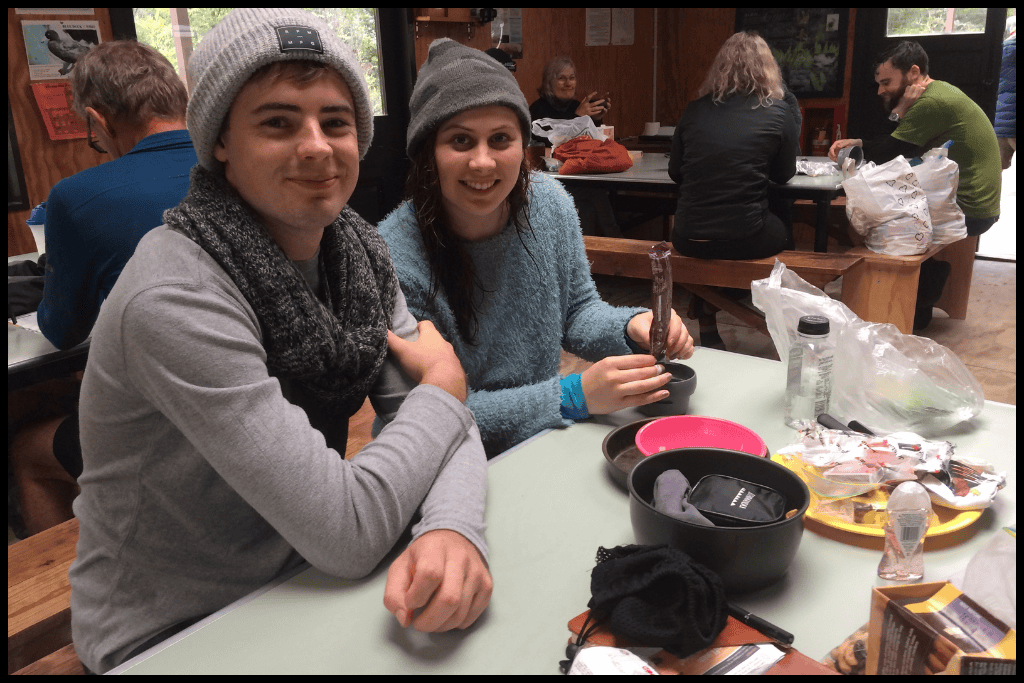 Author and her husband sit at the table at one of the Milford Track Department of Conservation huts.