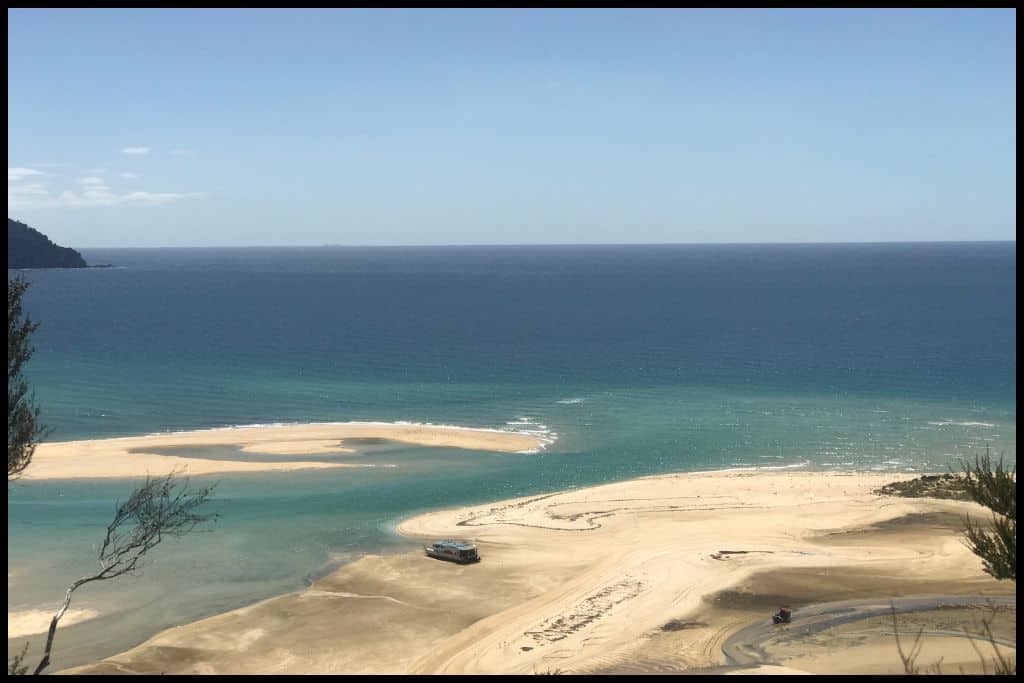 Photo taken from a viewpoint overlooking the turquoise waters and white sands of Awaroa Estuary on the Abel Tasman Coastal Track.