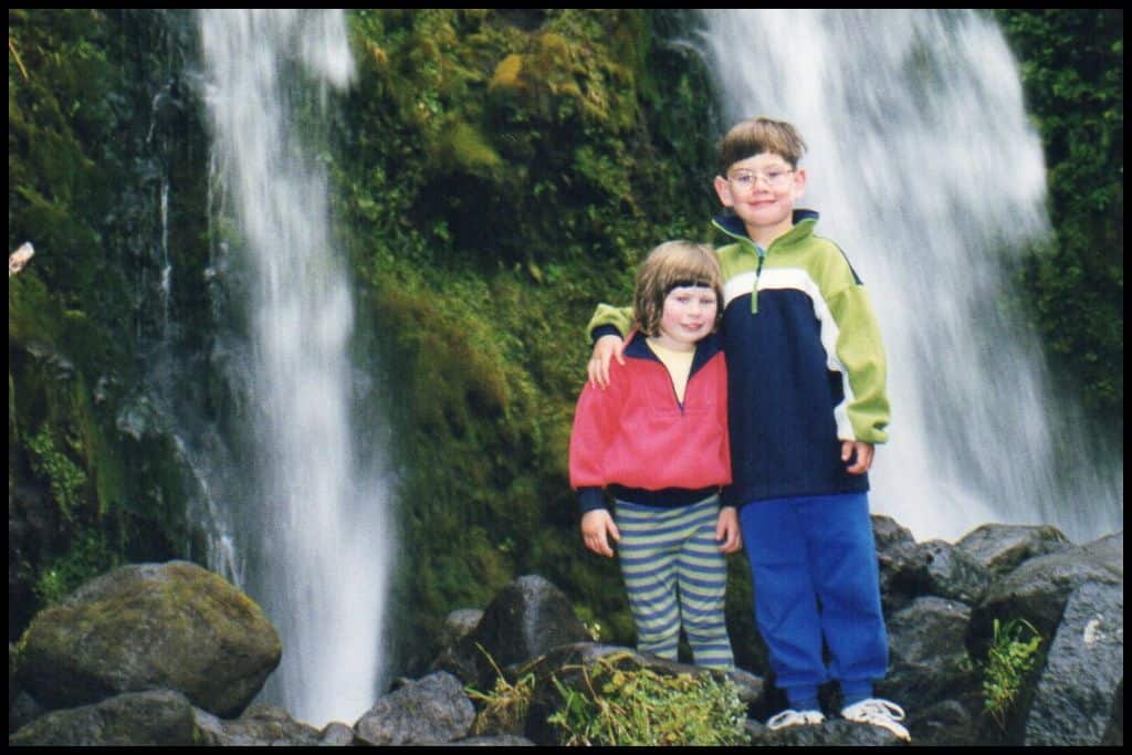 Two small children stand at the base of Dawson Falls.