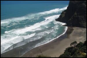 Blue surf washes up on the black sands of Mercer Bay, just south of Piha Beach and viewed from the Mercer Circuit.