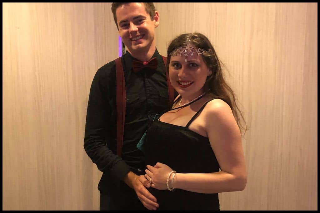 A couple in 1920s costume pose together.