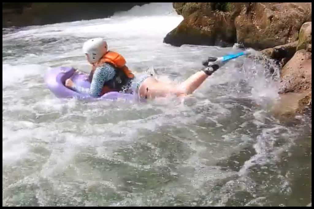 A young female holds a river board as she launches into the white water at Kaituna River Rafting.