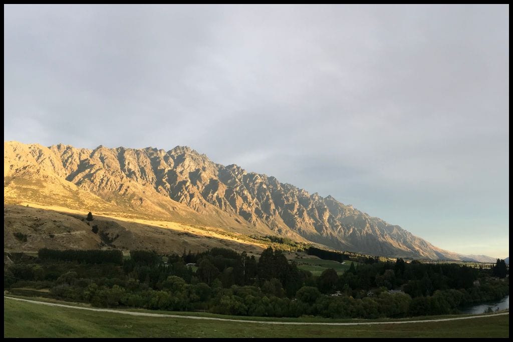 Late afternoon sun lights up the rocky Remarkables mountain range, pictured from below.