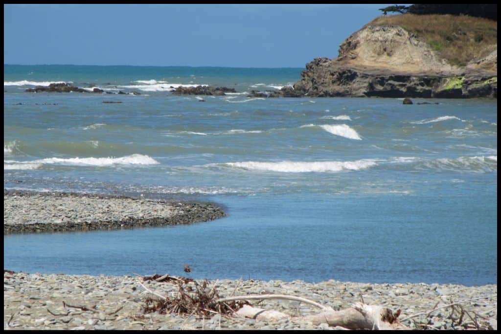 Blue surf meets the Waianakarua river mouth.