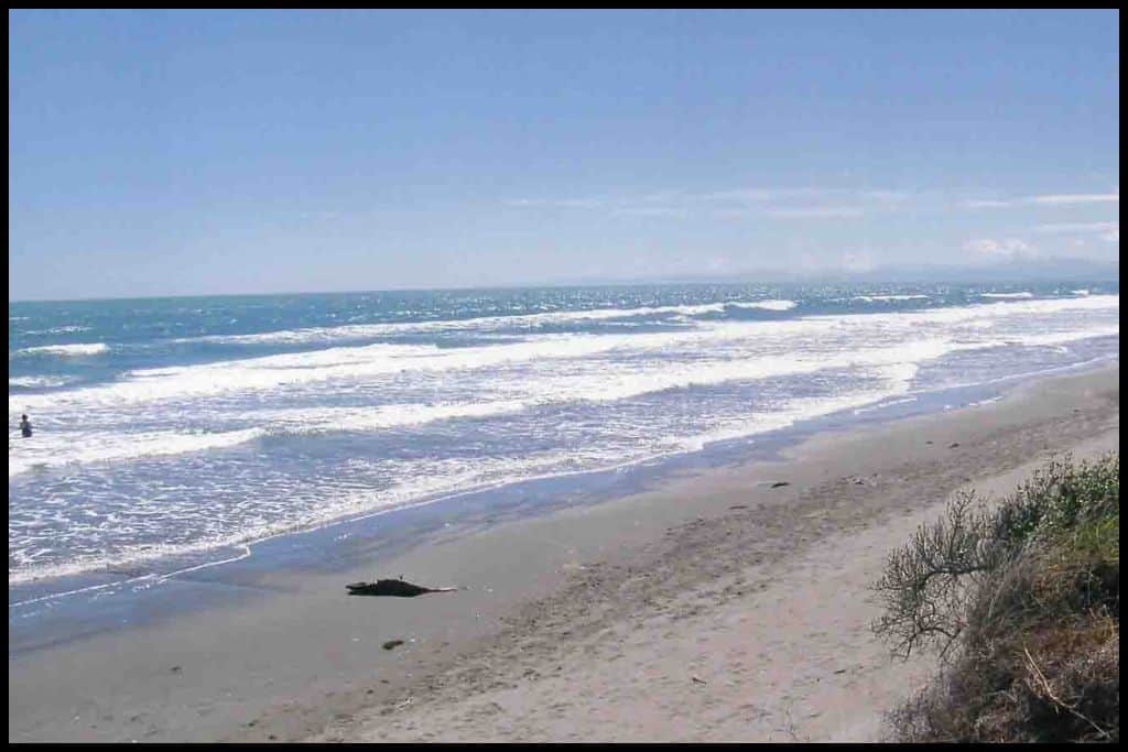 Photo captures white sand and rolling waves lapping at the shore.