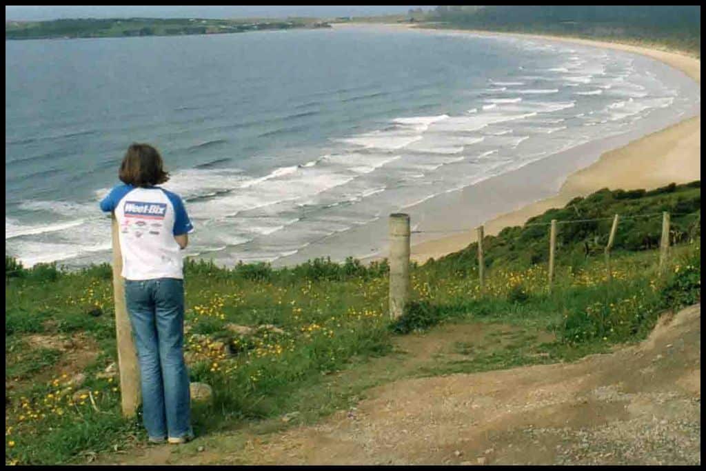 A young girl leans on a post at Florence Hill Lookout, gazing out to the Catlins coastline below.
