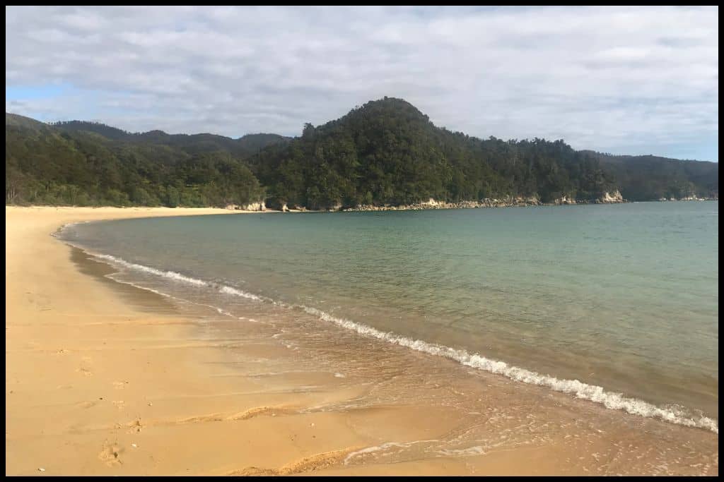 A scenic shot shows Anchorage Bay with its golden sand and clear waters.