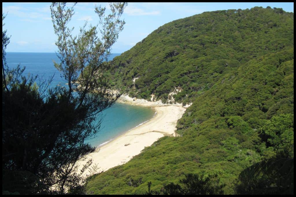 A high angle shot shows the beautiful clear water cove below.