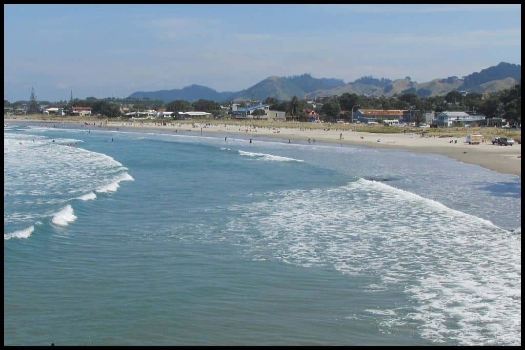 Surf breaks onto shore of a popular sandy beach.