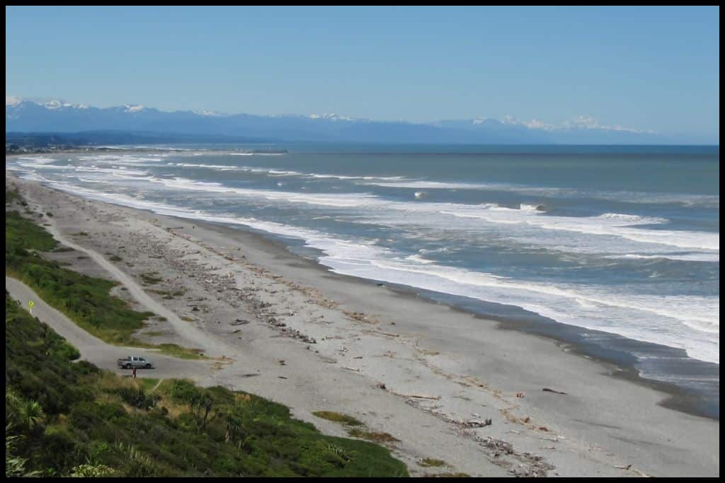 A high angle shot shows Point Elizabeth Beach, vast amounts of sand and water, and a solo ute parked in the carpark.
